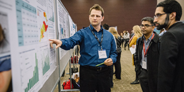 People participating in scientific poster presentation.